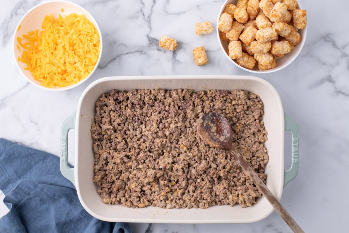 spreading ground beef mixture in a casserole dish