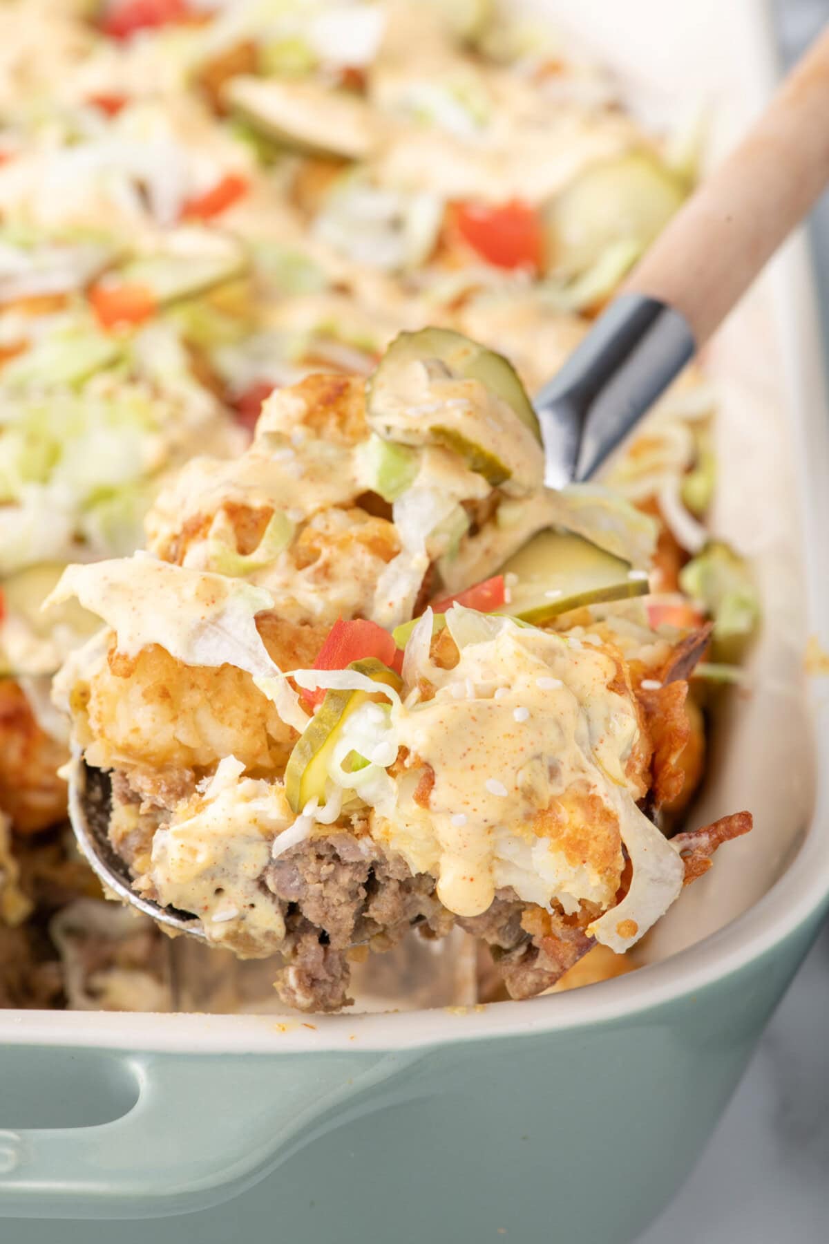 Spoonful of Big Mac Casserole being lifted out of a casserole dish