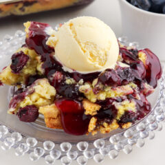 Blueberry Dump Cake on a plate topped with a scoop of ice cream