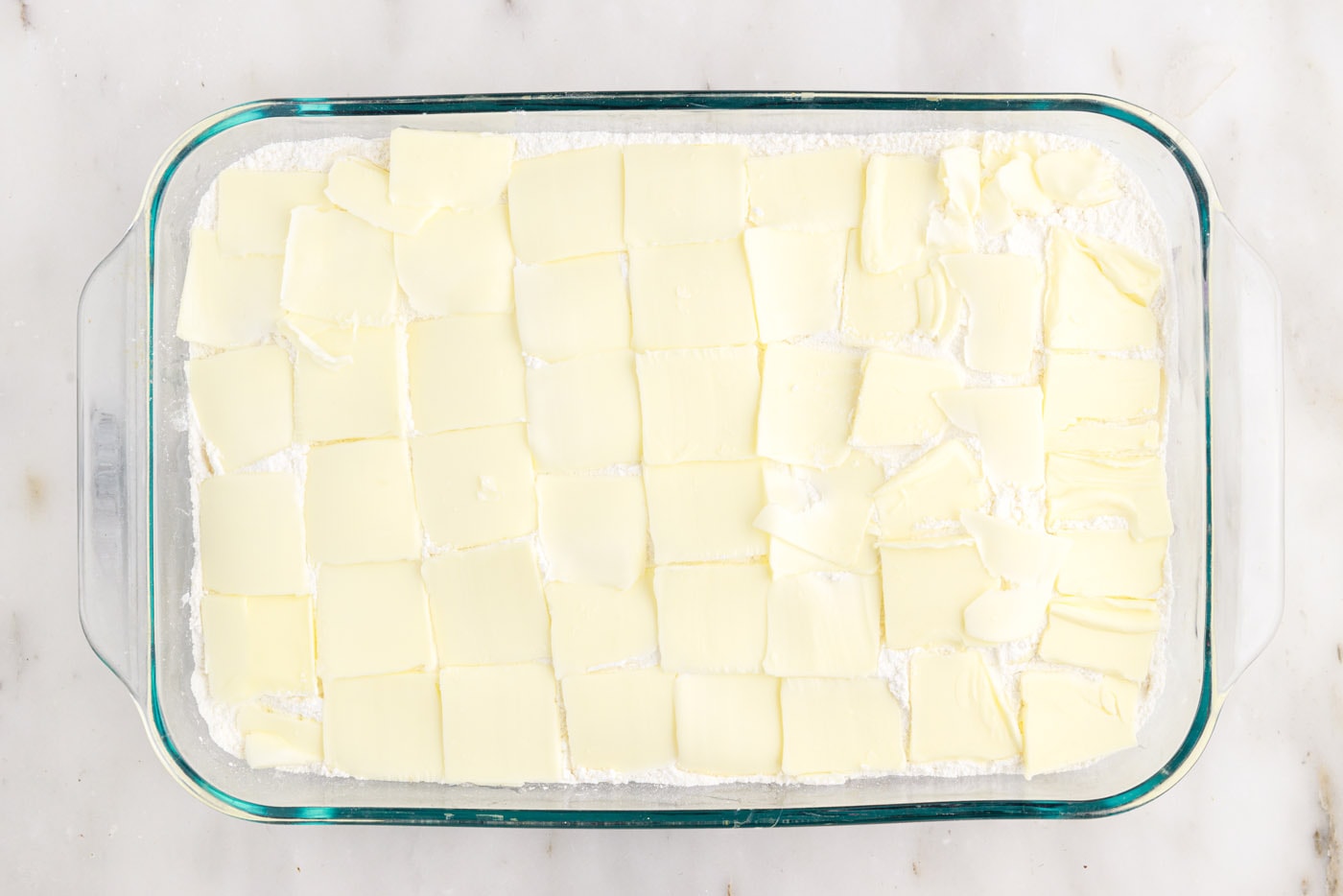 pats of butter on top of cake mix in a baking dish