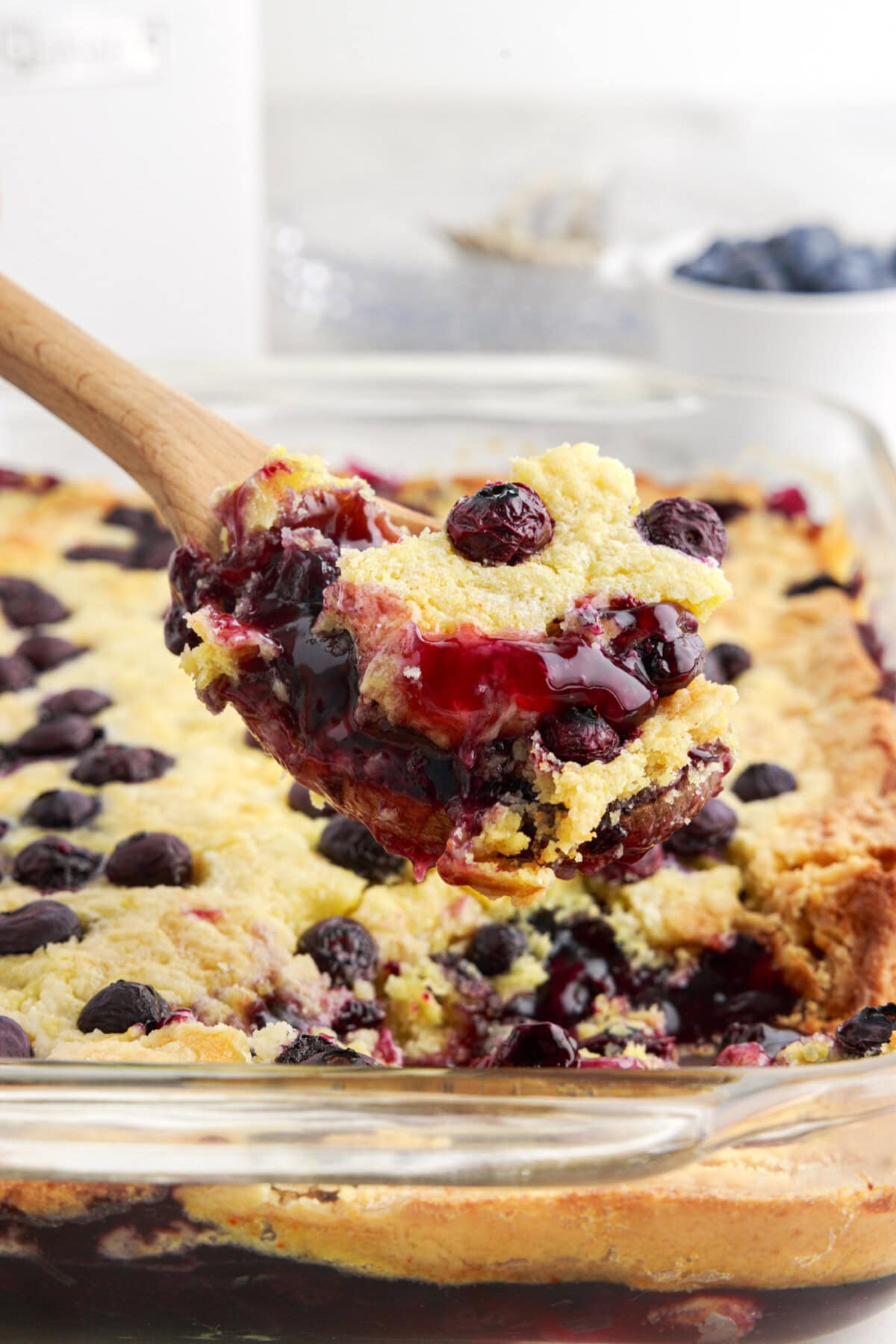 Spoonful of Blueberry Dump Cake being lifted out of the pan