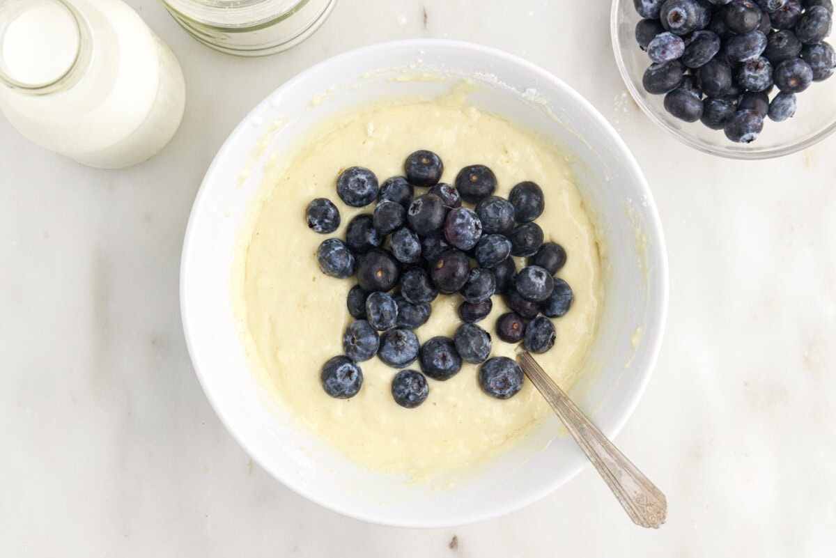 folding fresh blueberries into pancake batter