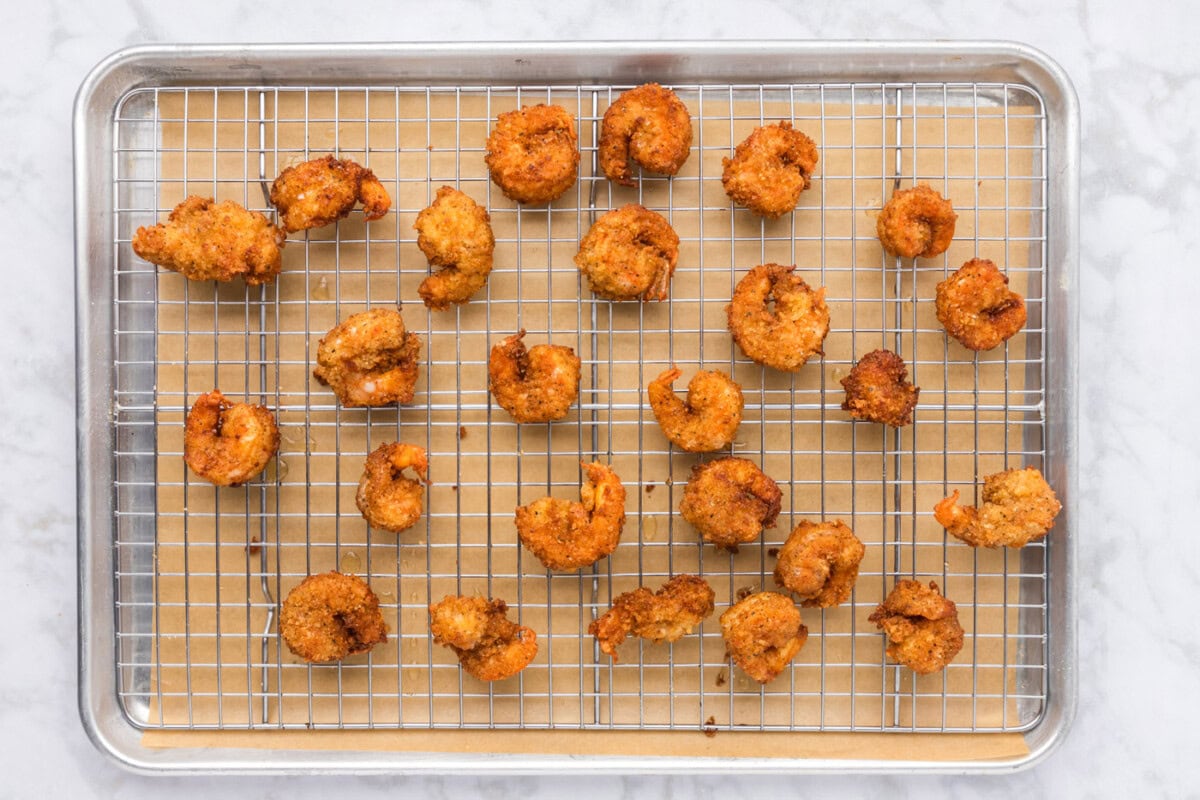golden fried breaded shrimp on a baking sheet