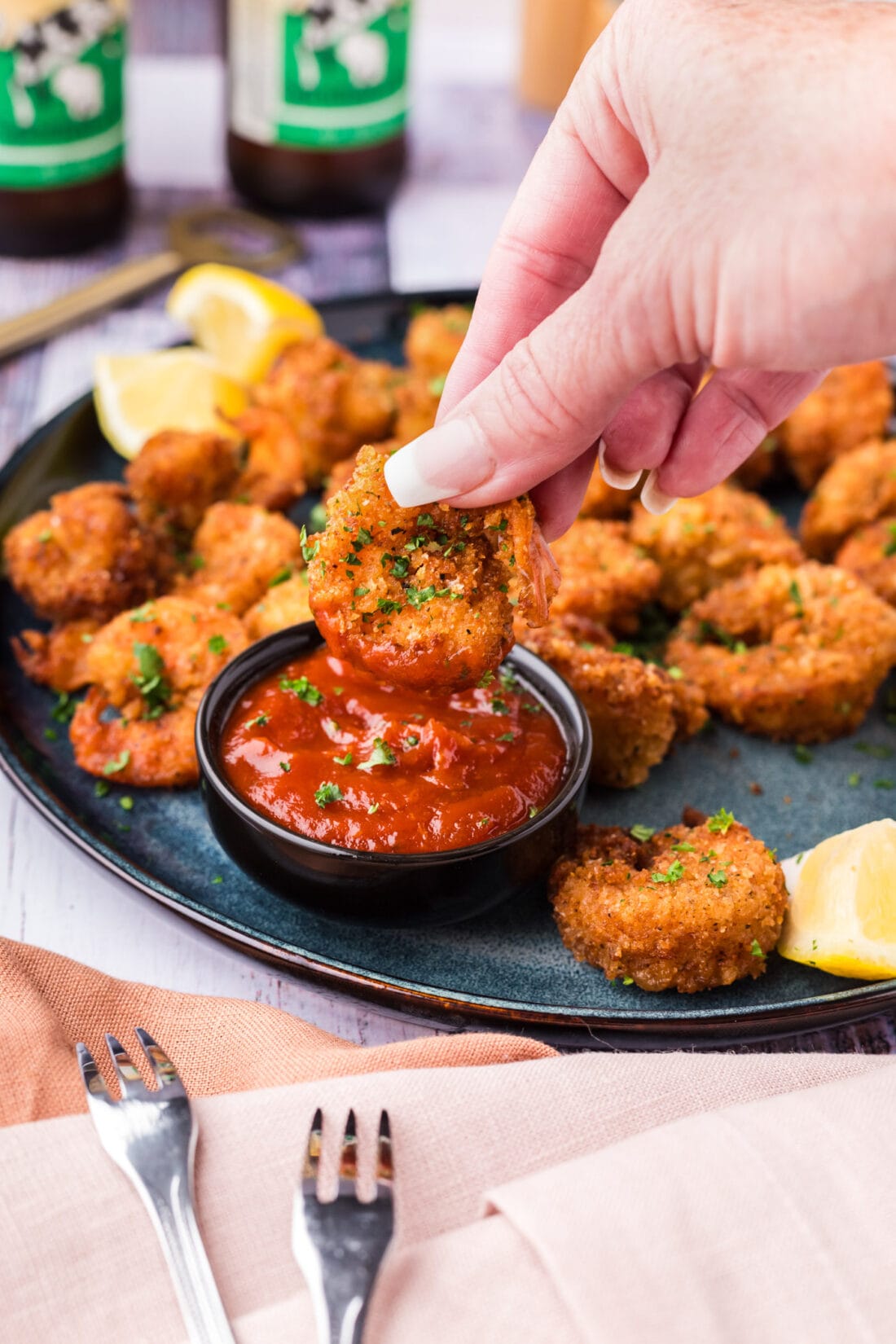 Breaded Shrimp being dipped in cocktail sauce 