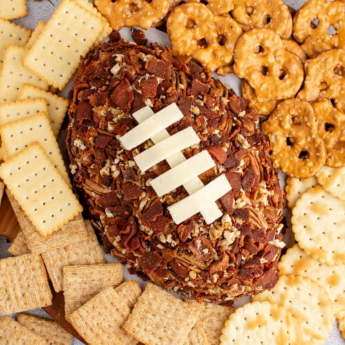 Close up photo of a Football Cheese Ball with crackers around it