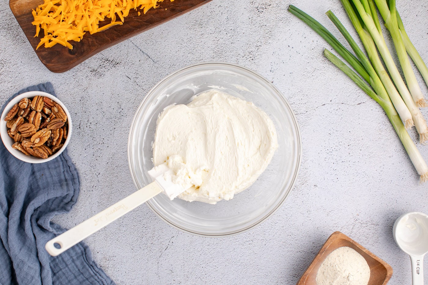rubber spatula in a bowl of cream cheese and sour cream mixture