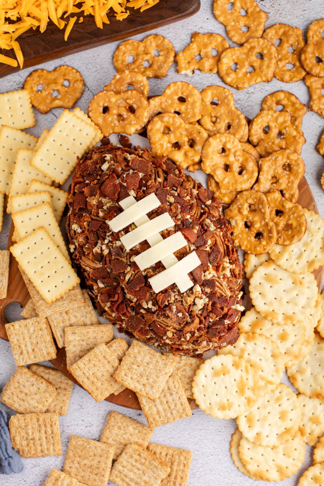 Overhead photo of a Football Cheese Ball with crackers around it