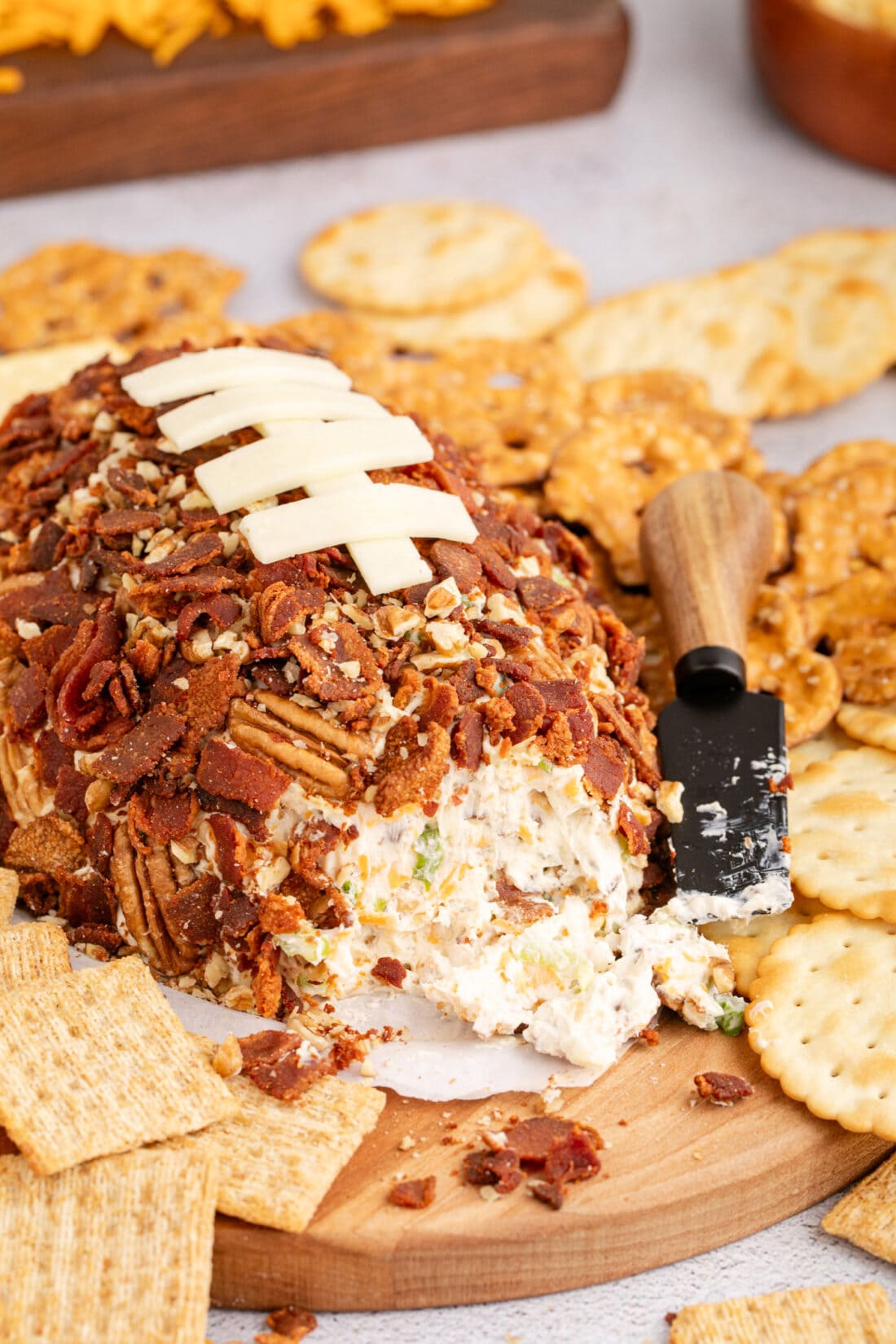 Football Cheese Ball on a platter with some removed 