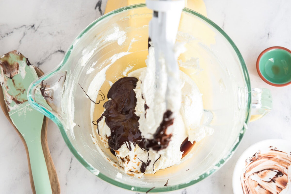 cooled chocolate and vanilla added to butter and sugar mixture in a bowl