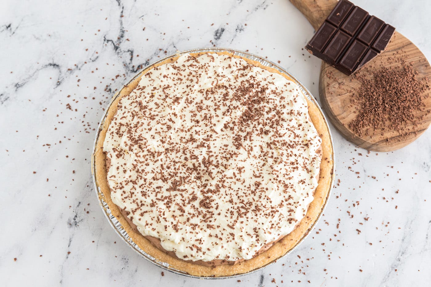 French silk pie topped with whipped cream and shaved chocolate