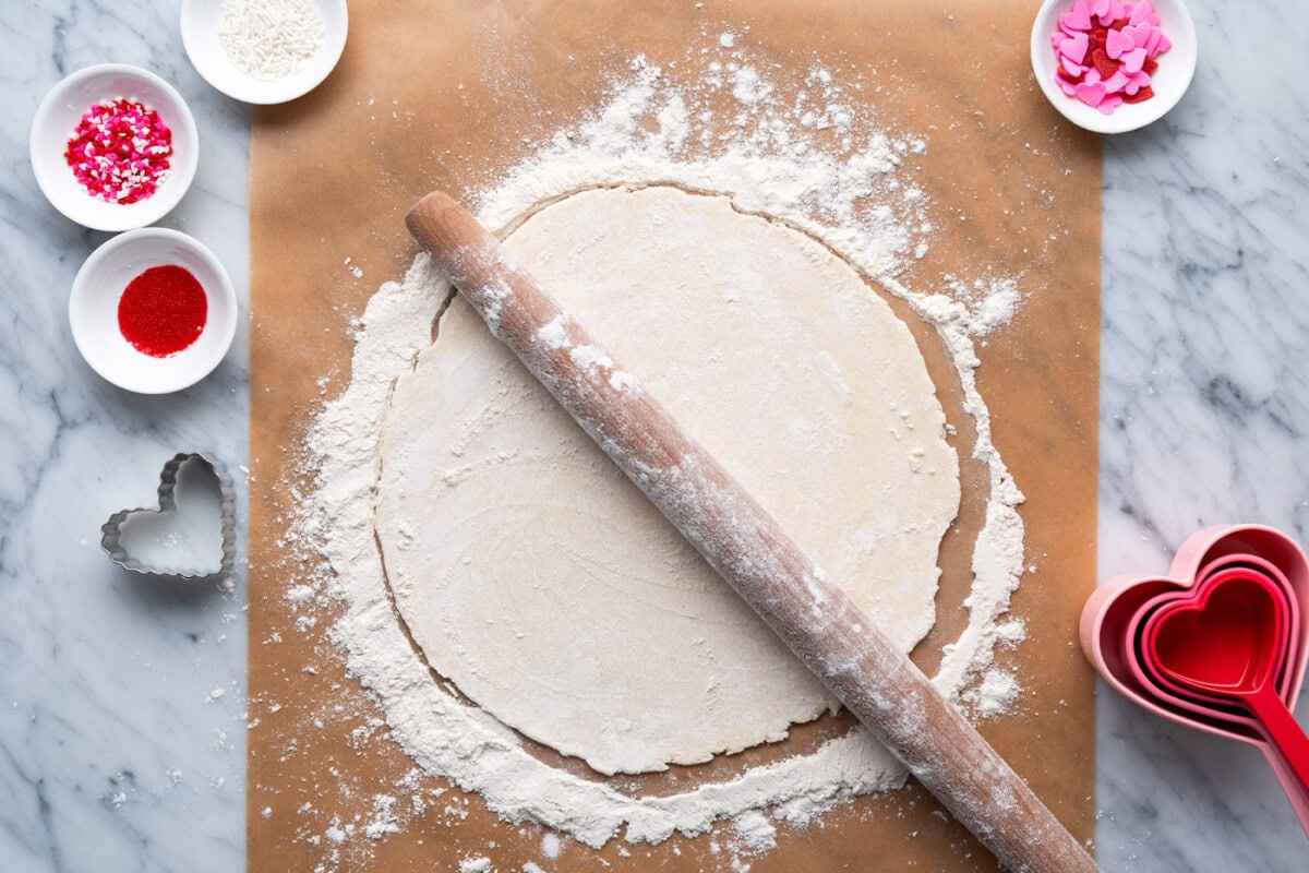 rolling pin on top of flattened pie dough