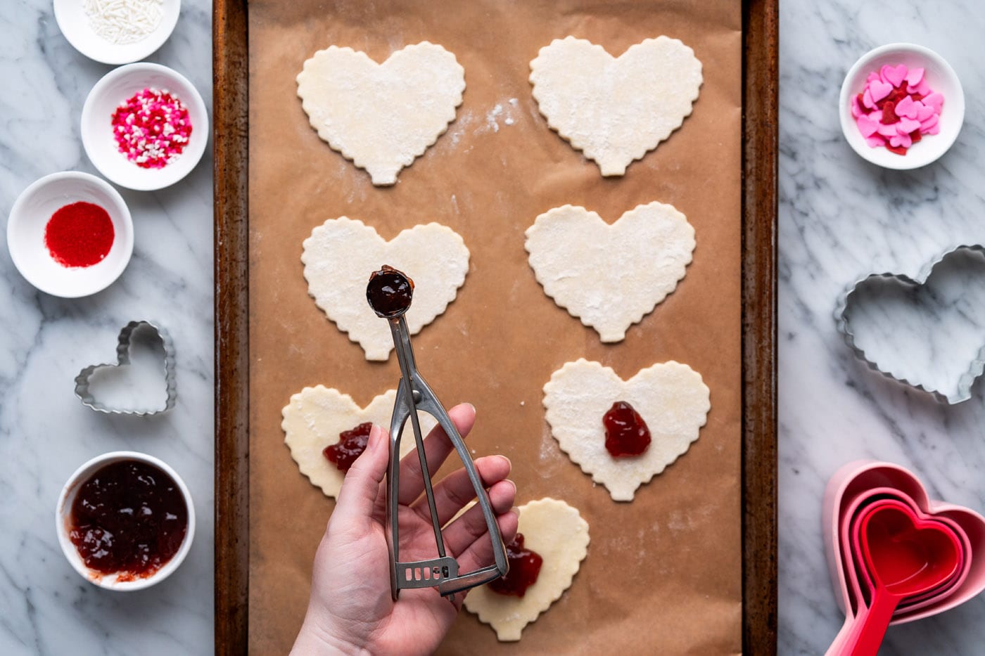 adding strawberry jam to center of heart shaped pie