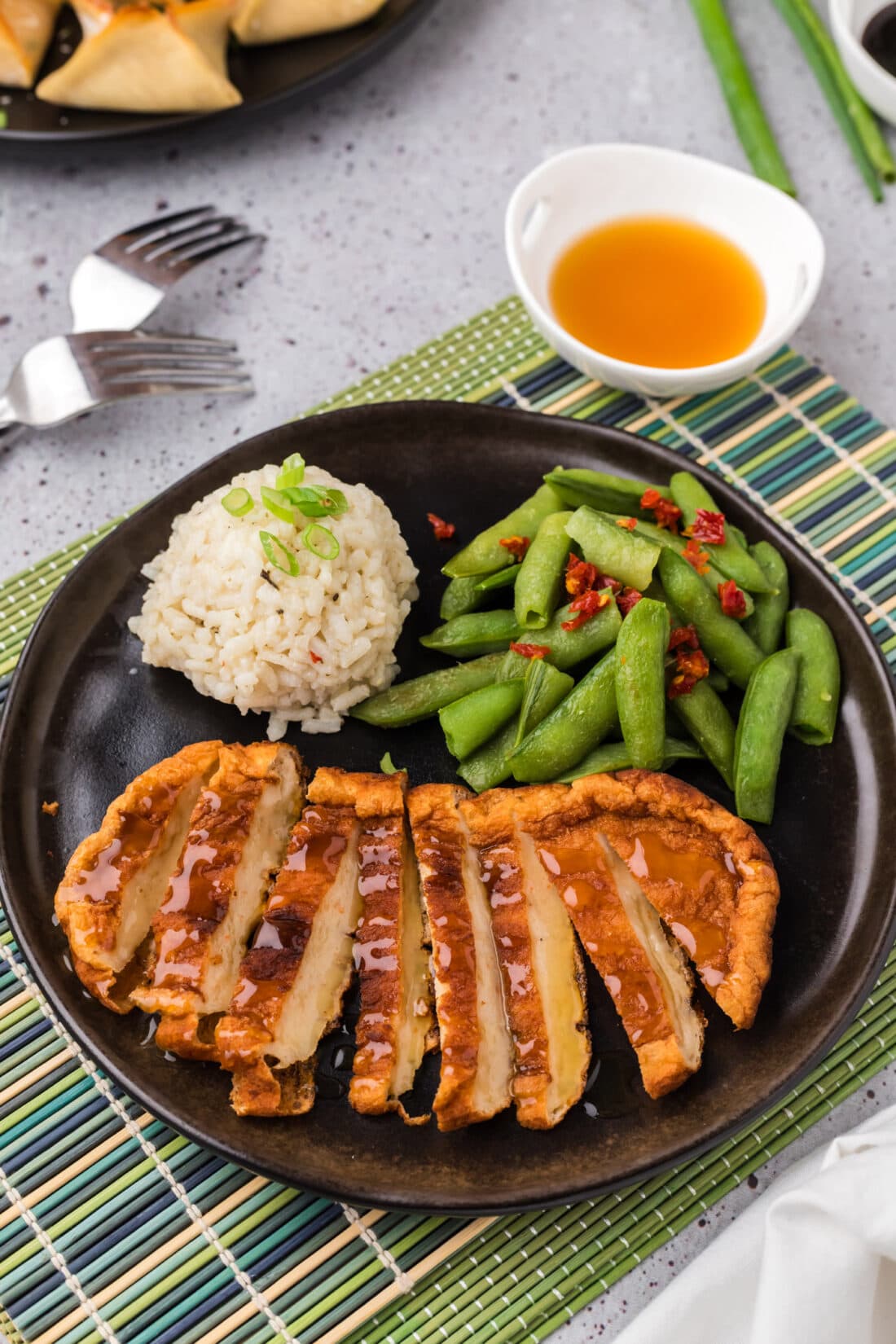 Korean Fish Cake sliced on a plate with rice and snap peas