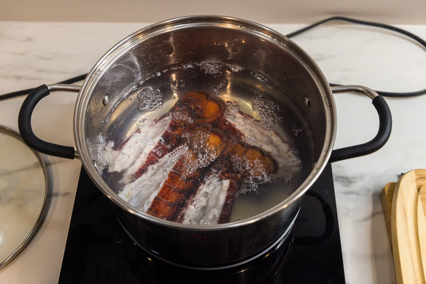 lobster tails cooking in a stockpot