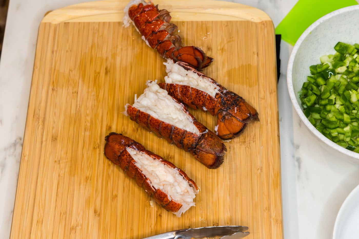 cooked lobster tails on a cutting board