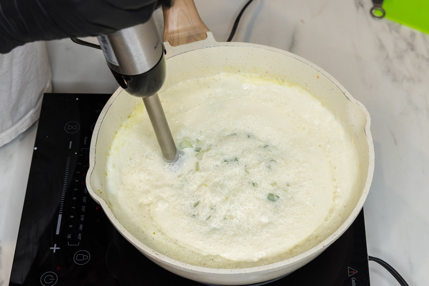 using an immersion blender to break up chunks in pasta sauce