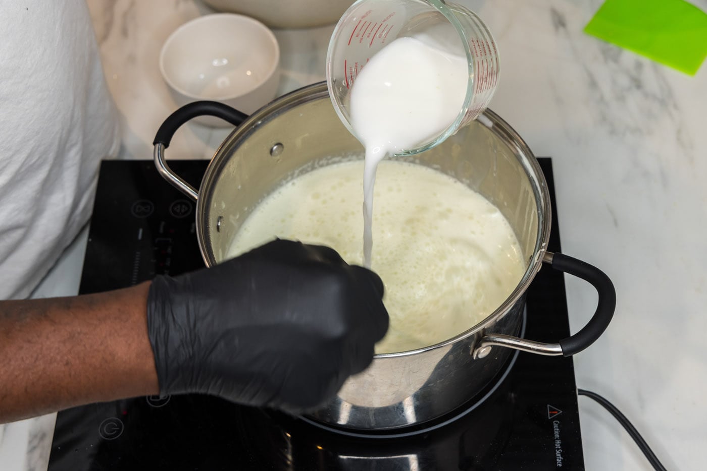whisking cornstarch slurry into sauce in a pot