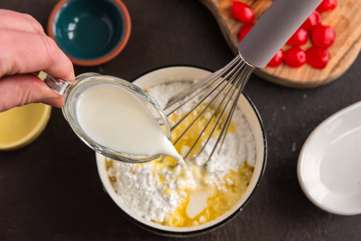 whisking milk into powdered sugar and melted butter