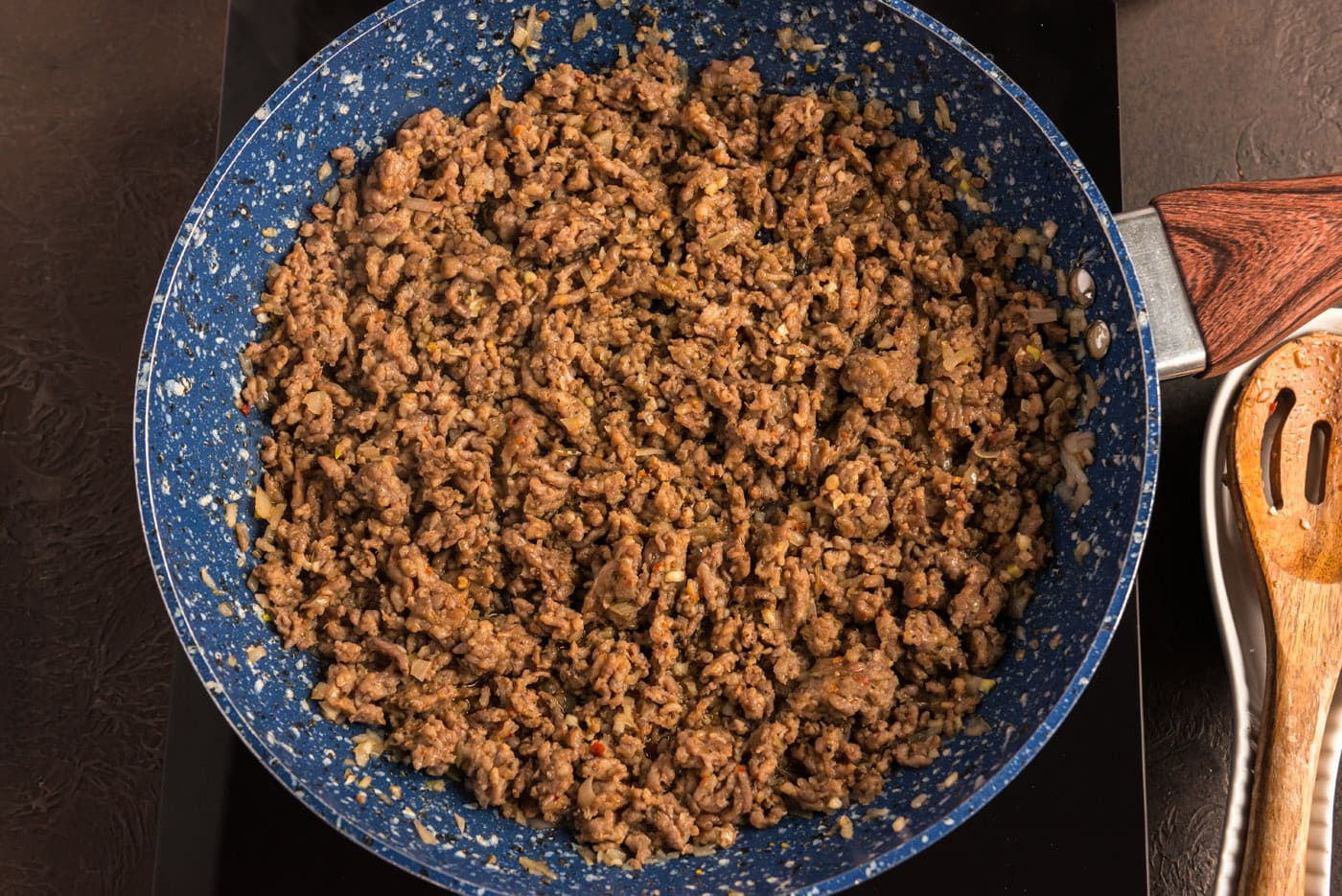 cooked ground pork sausage in a skillet with shallots and garlic