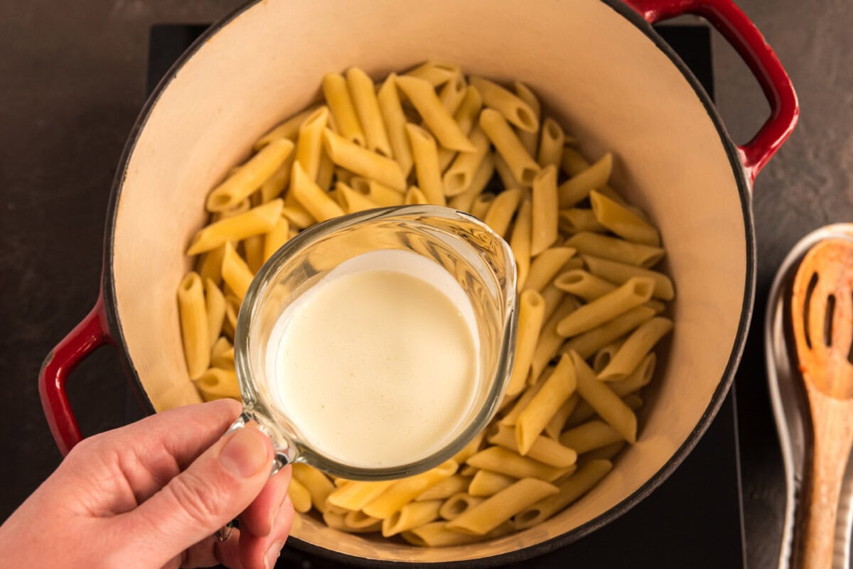 adding cream to penne pasta
