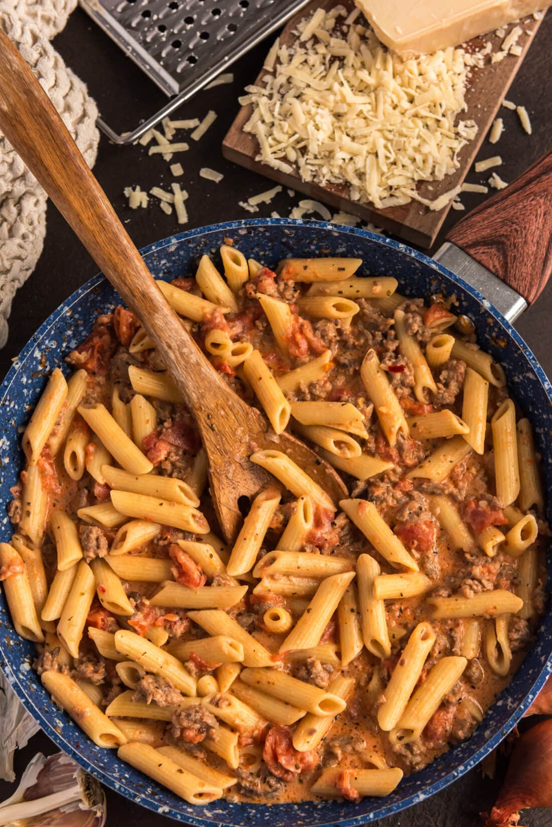 Penne with Tomato Sage Sausage Sauce in a skillet with a spoon