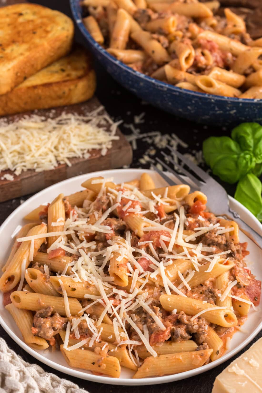 Plate of Penne with Tomato Sage Sausage Sauce topped with cheese