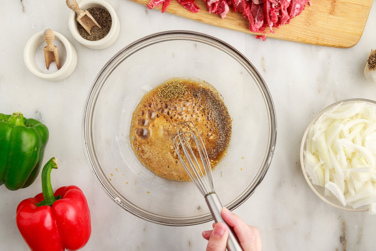 whisking marinade ingredients in a bowl