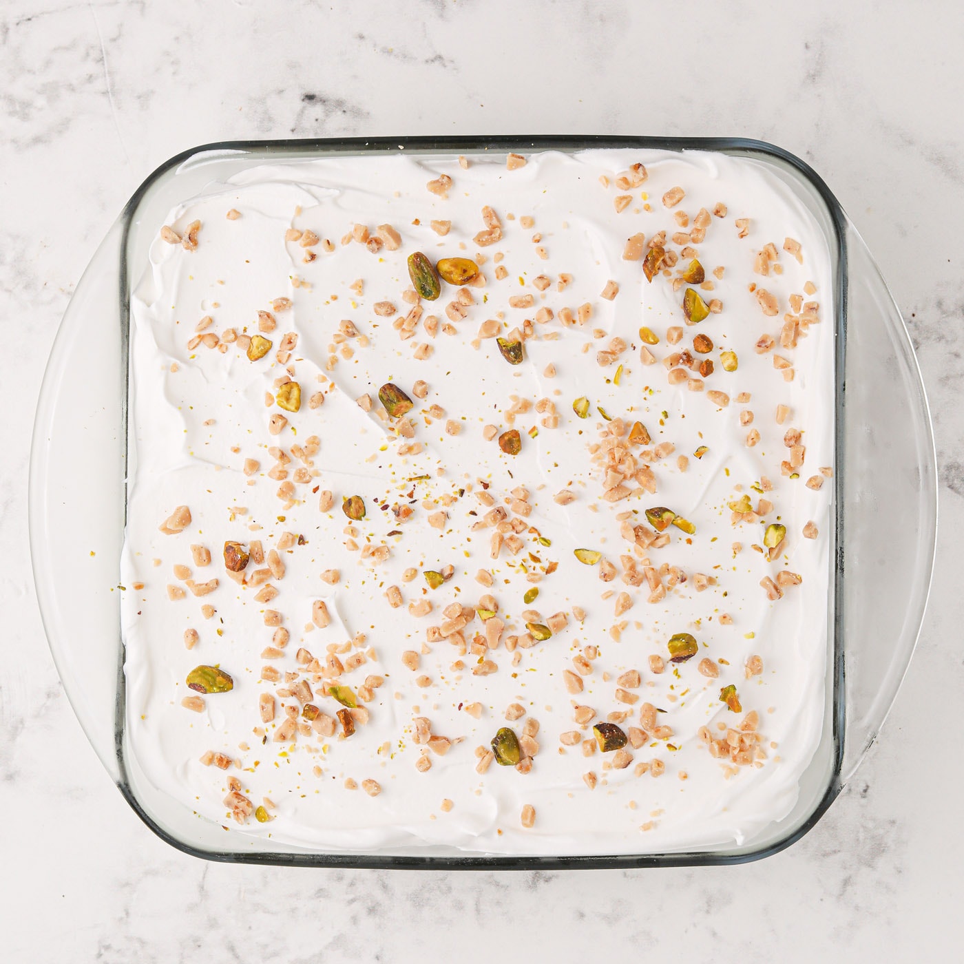 crushed pistachios on top of cool whip and pistachio ice cream