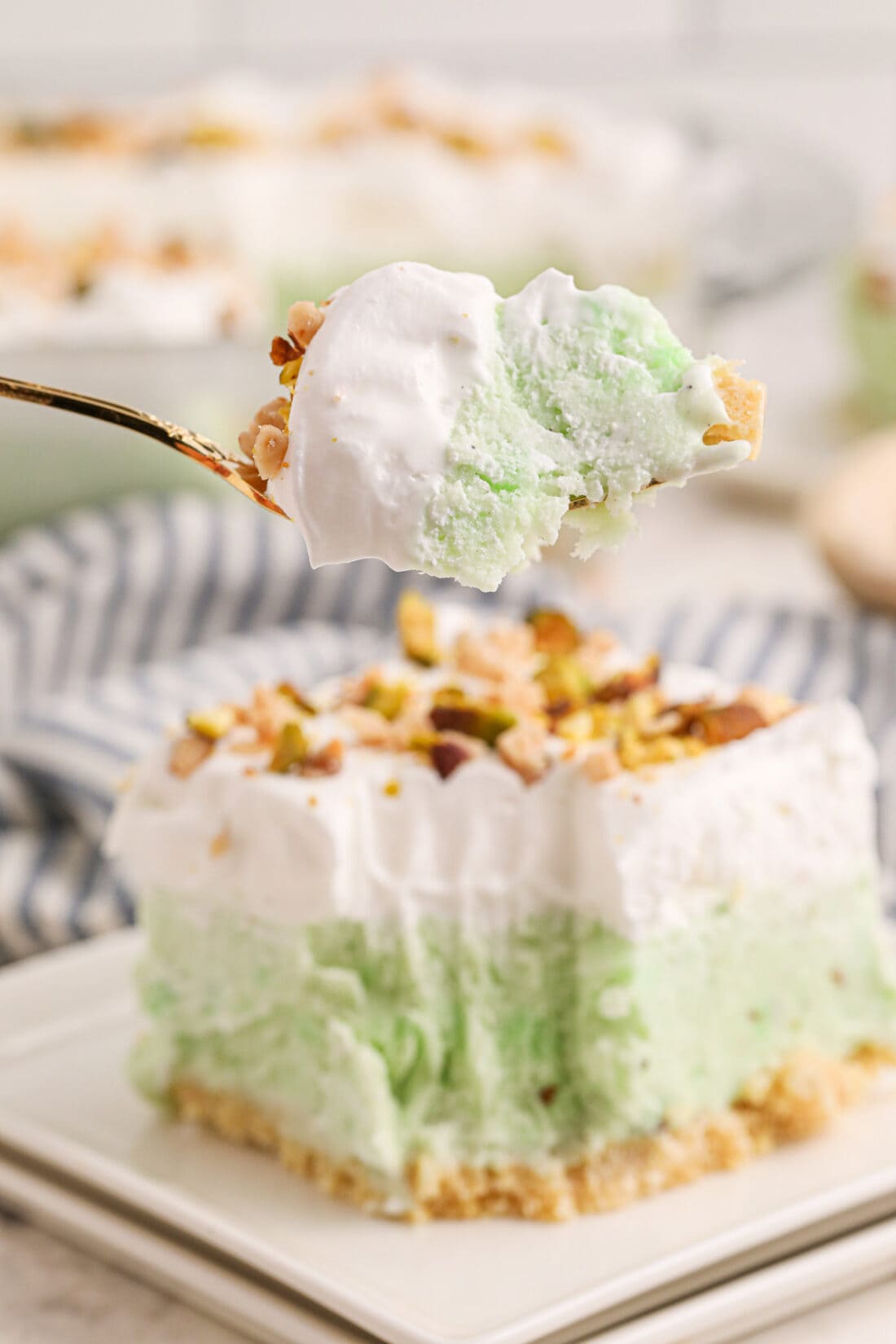 Pistachio Ice Cream Cake on a fork with a slice behind it on a plate