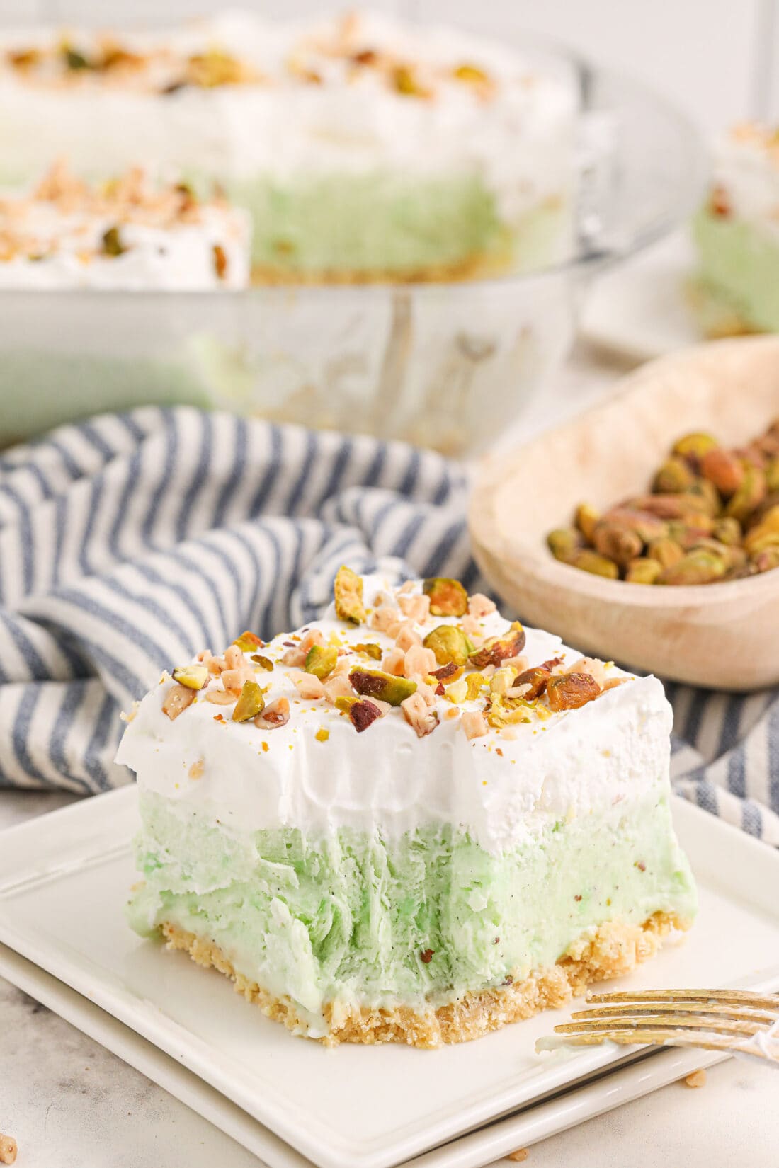 Slice of Pistachio Ice Cream Cake on a plate with a bite removed