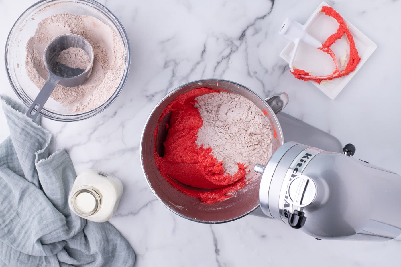 mixing red velvet cupcake batter with cocoa powder