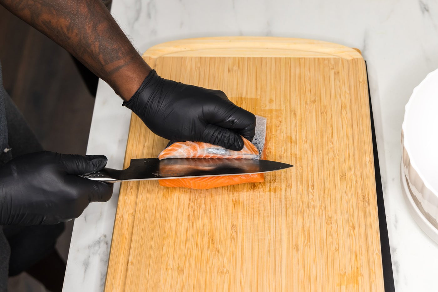 Removing skin from salmon filet with a knife