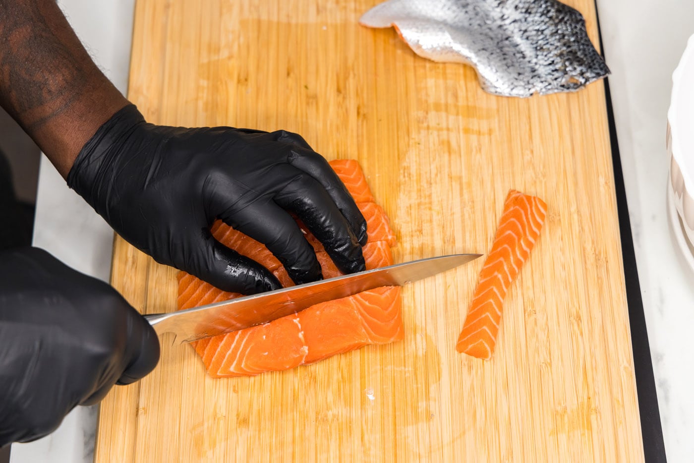slicing salmon filet into strips