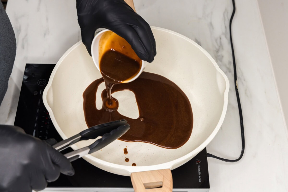 adding salmon marinade to pan