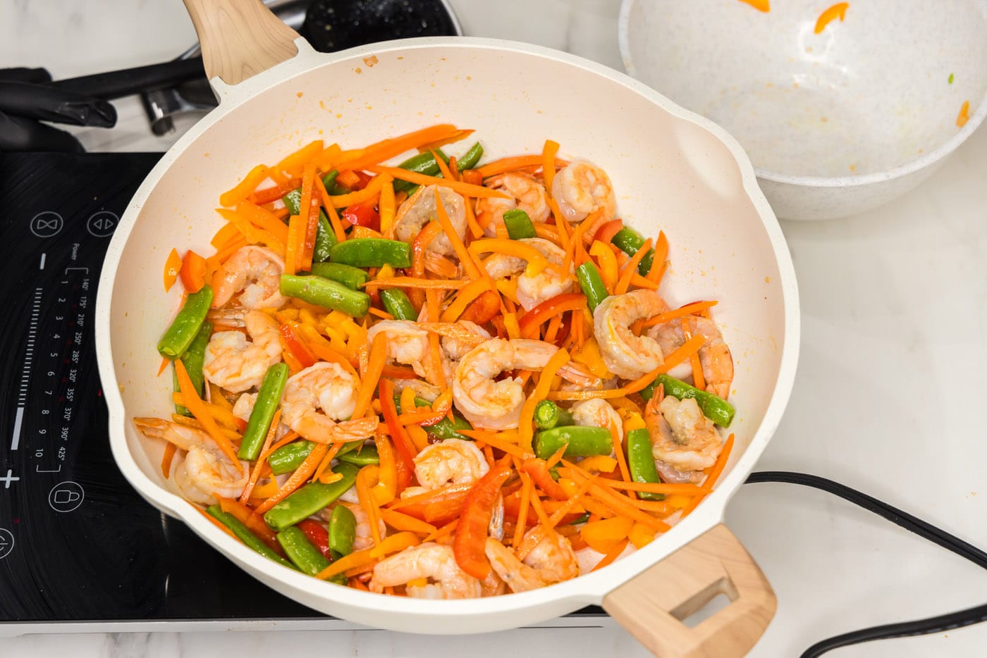 carrots, snap peas, and bell peppers added to skillet with shrimp