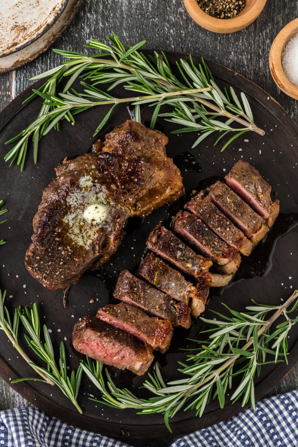Two Sous Vide Steaks on a platter with one cut into slices