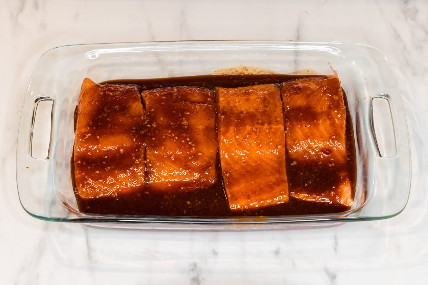 salmon filets in a dish with spicy marinade
