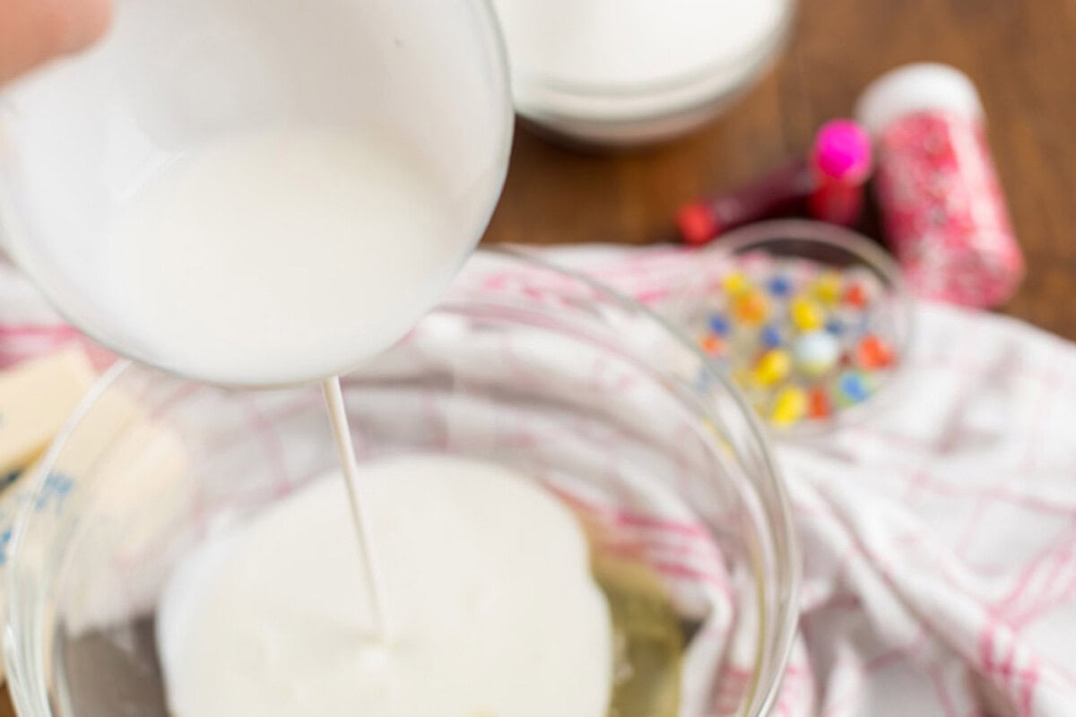 Buttermilk being poured into a bowl of egg whites