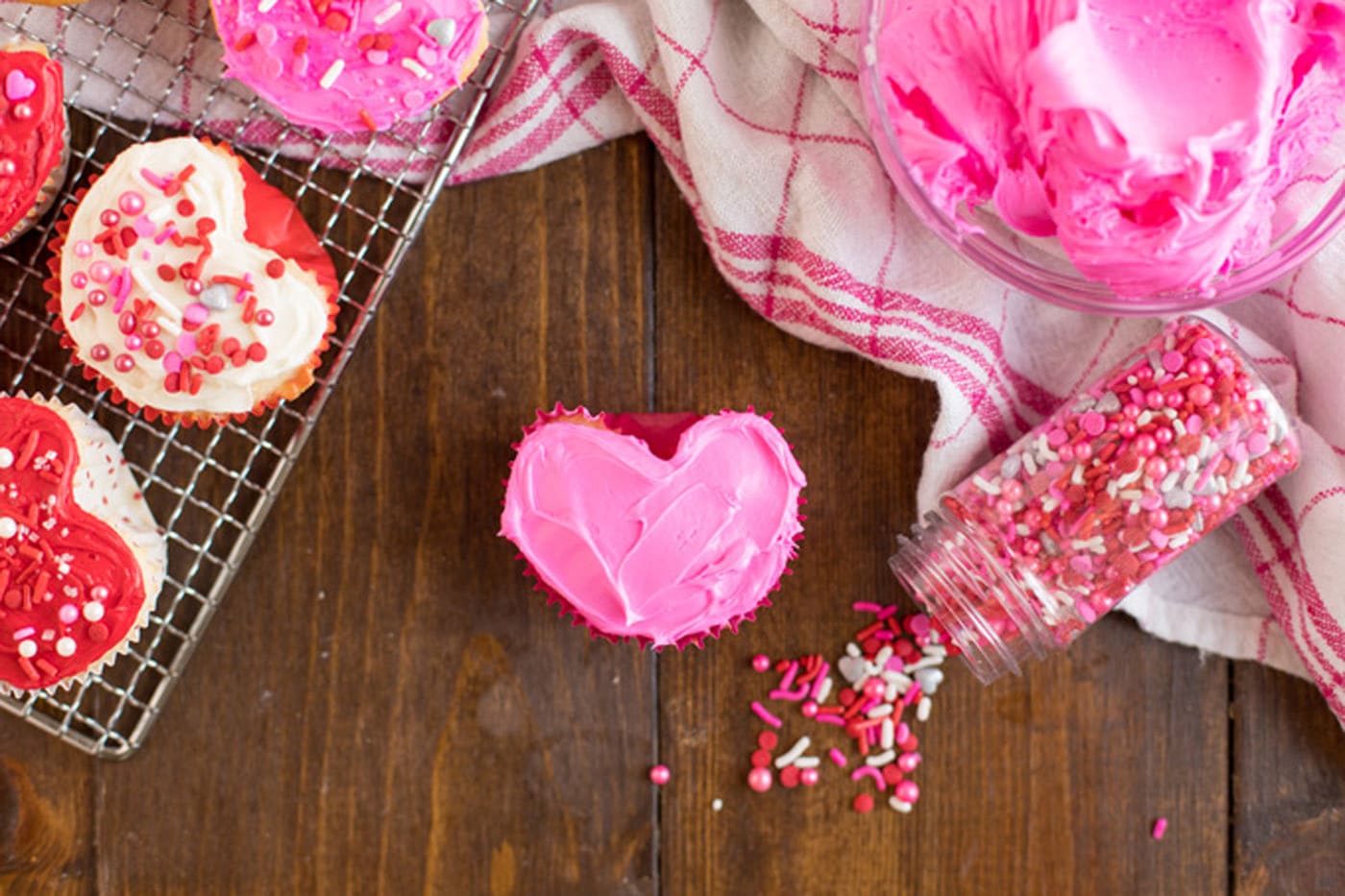 Valentine Heart Cupcake frosted with pink frosting and sprinkles on the side