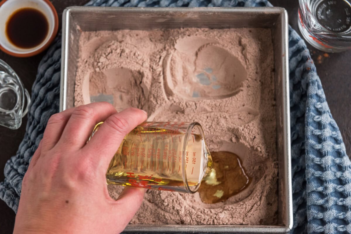 pouring oil into well of wacky cake