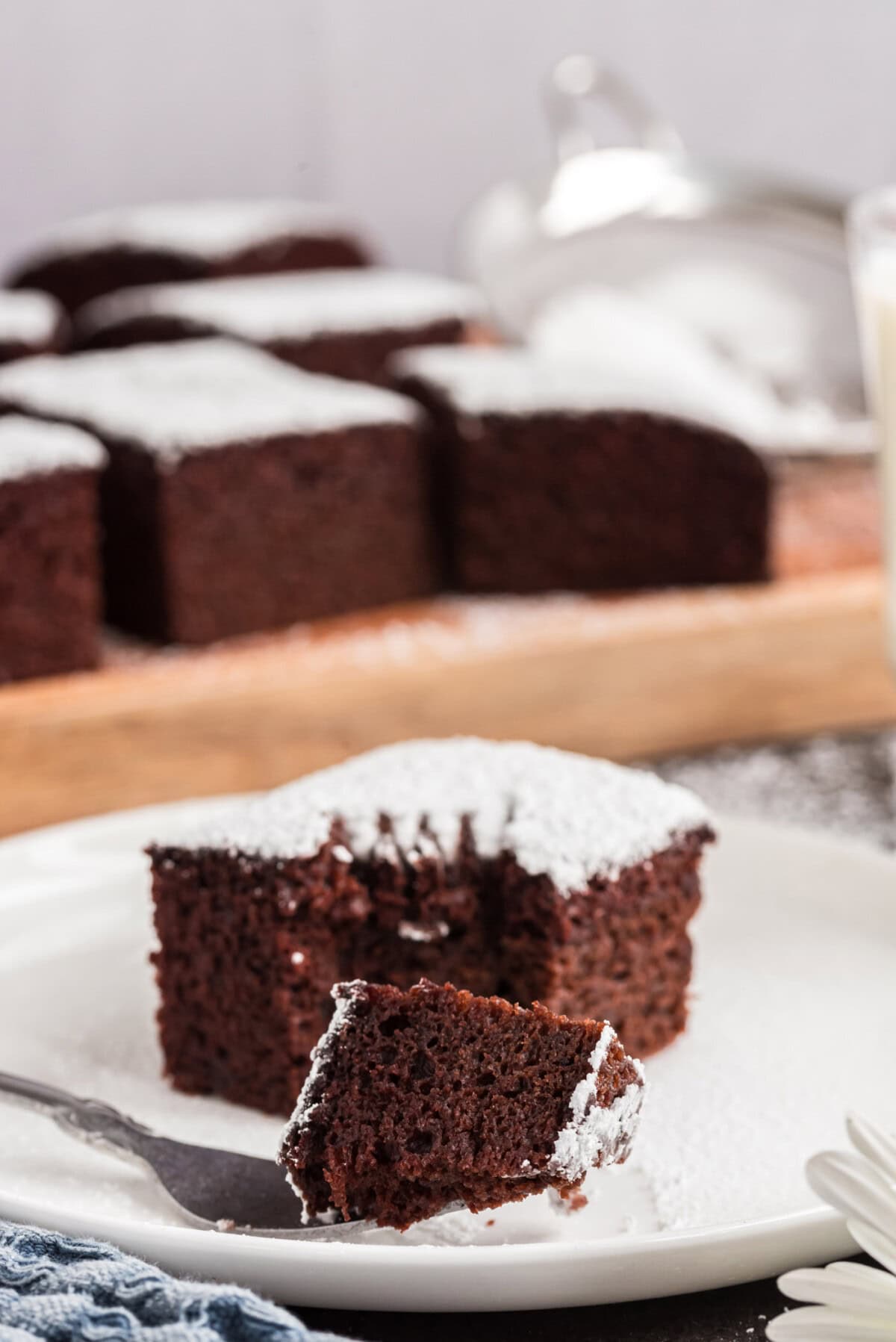 Piece of Wacky Cake on a fork with a square of Wacky Cake behind it