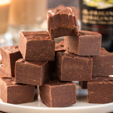 Close up photo of a stack of fudge squares with a bite taken out of the top square