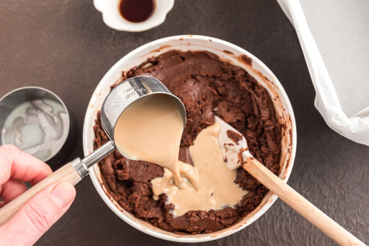 pouring Bailey's Irish cream into chocolate mixture