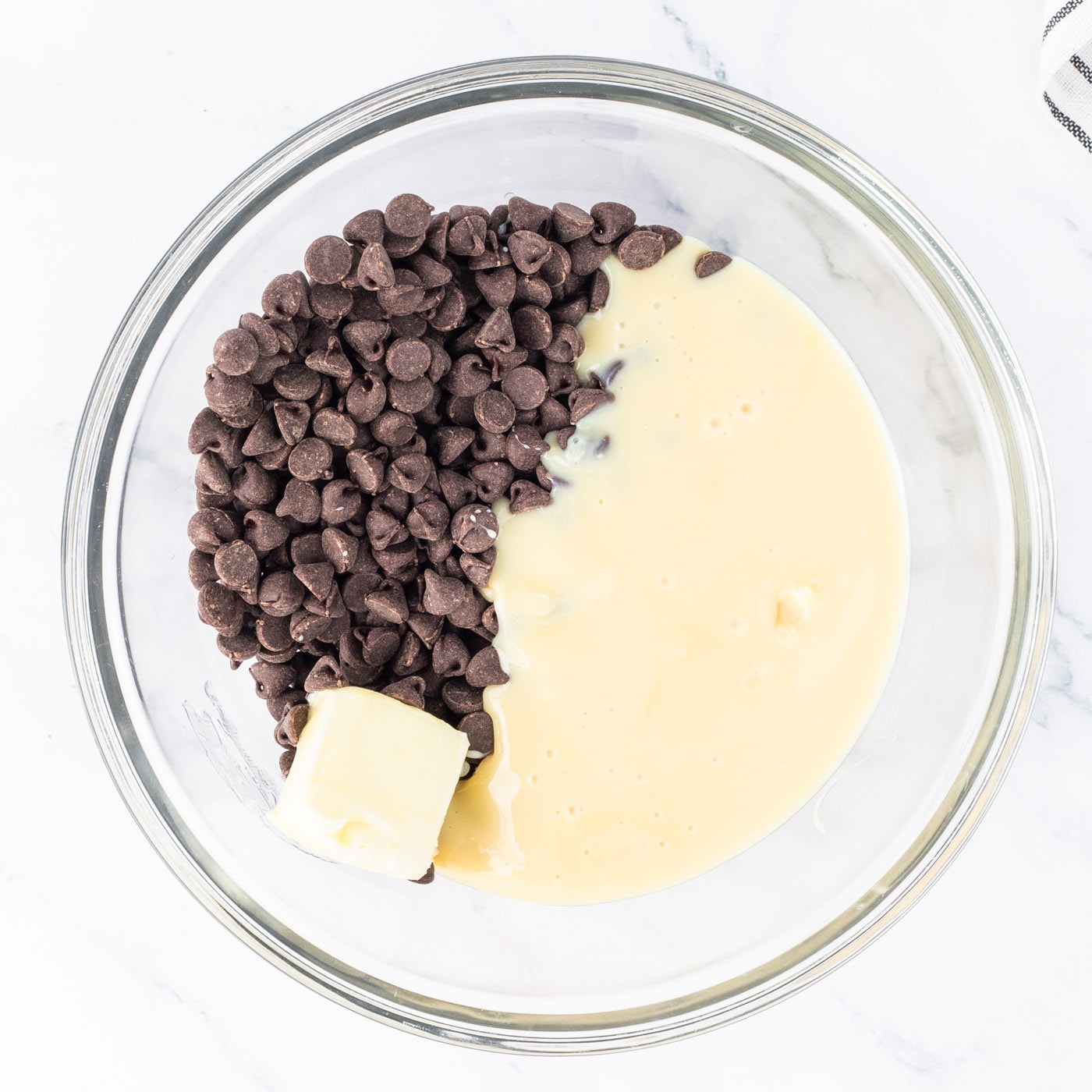 semi sweet chocolate chips in a bowl with butter and sweetened condensed milk