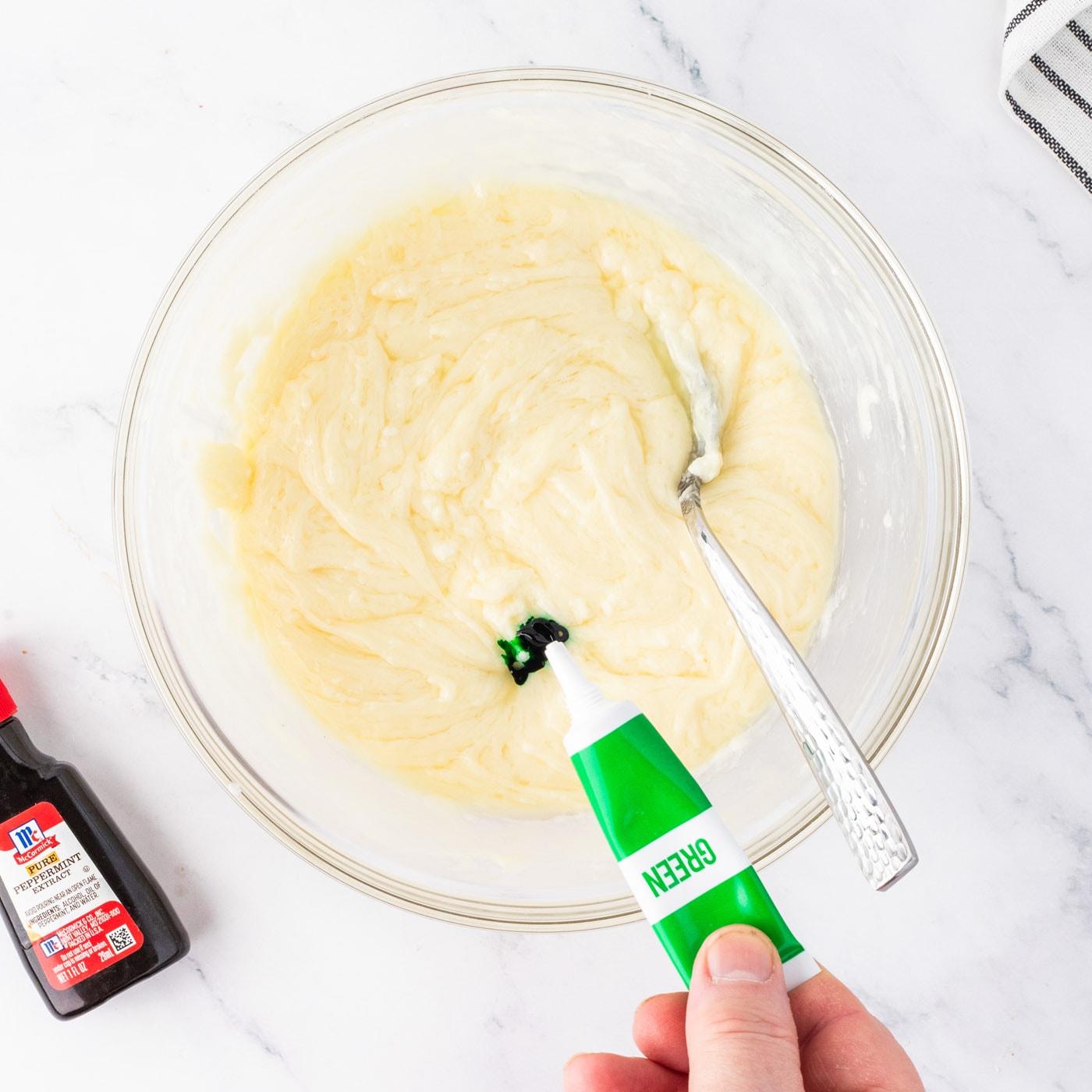 adding green food coloring and peppermint extract to white chocolate fudge