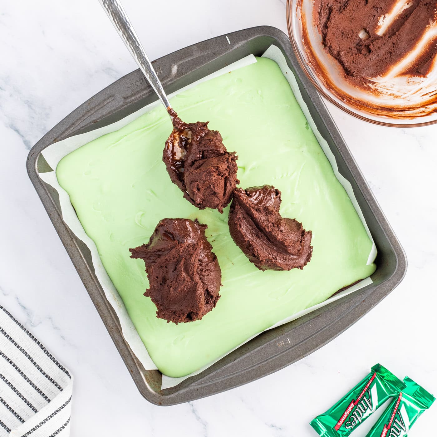 spreading chocolate layer over mint fudge