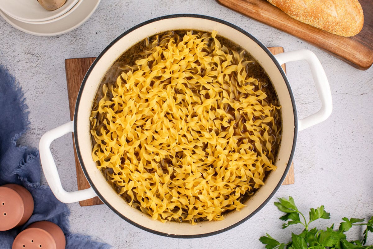 egg noodles added to pot with beef and vegetable soup