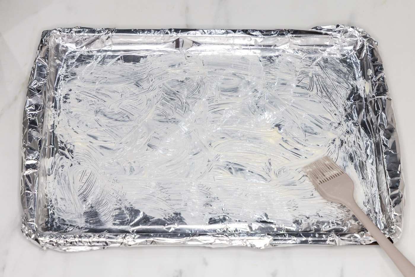 brushing aluminum foil with softened butter