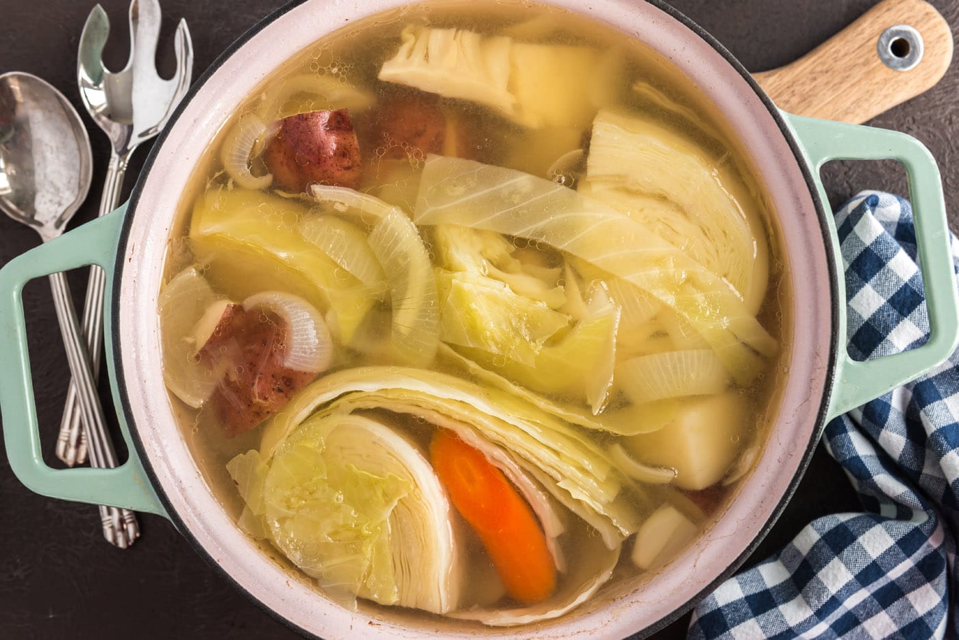 corned beef and cabbage with carrots and onion in a dutch oven
