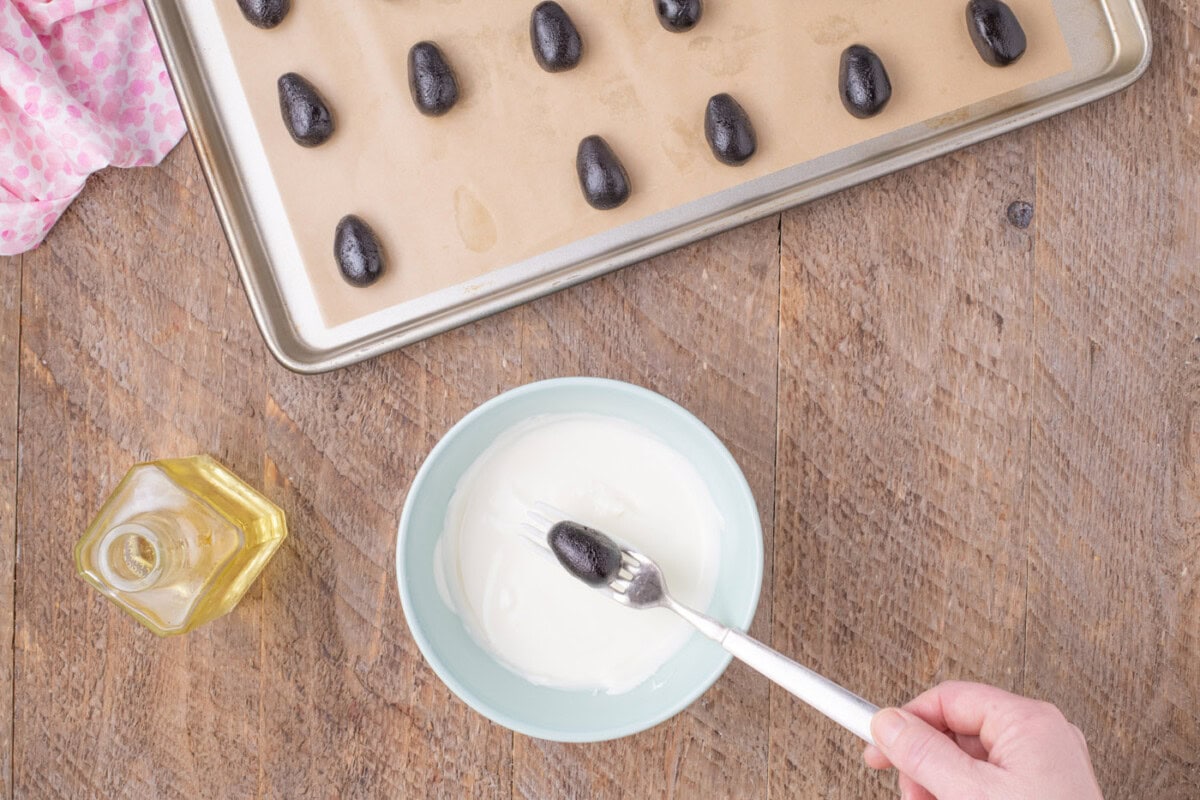 dipping Easter egg Oreo truffles in white chocolate